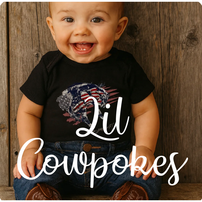 “Happy baby in cowboy boots and patriotic tee, representing Rust and Redemption’s faith-inspired Lil Cowpokes kids collection”